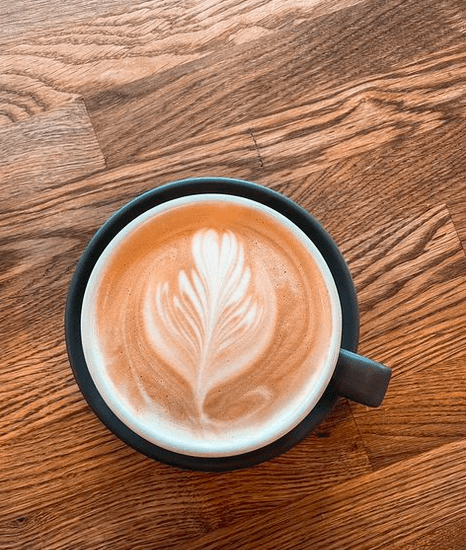 a coffee with latte art on a wooden table