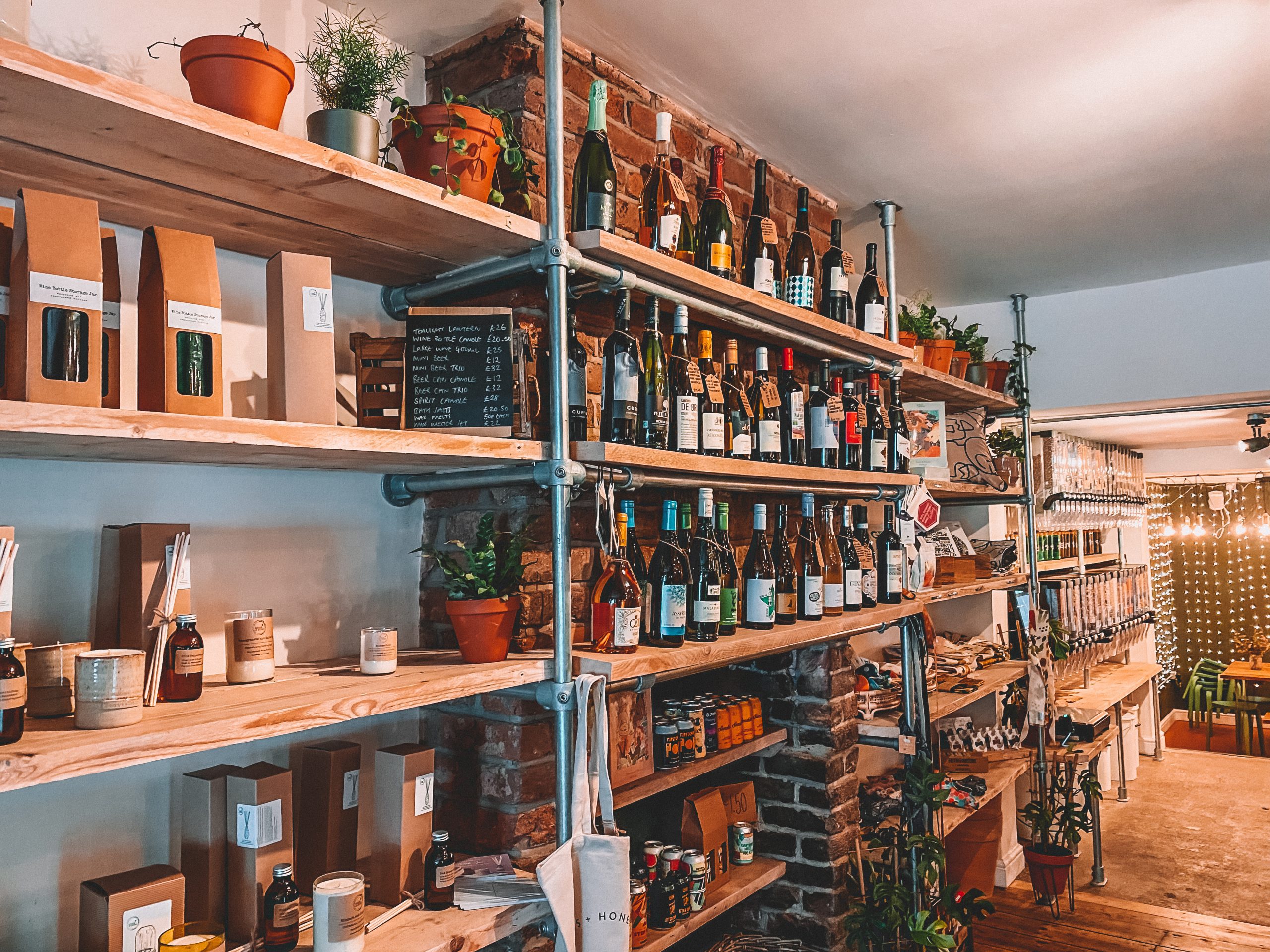 shelves inside a store filled with homemade candles, wine bottles, beers and gifts